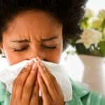 getty_rf_photo_of_woman_blowing_her_nose_near_bouquet